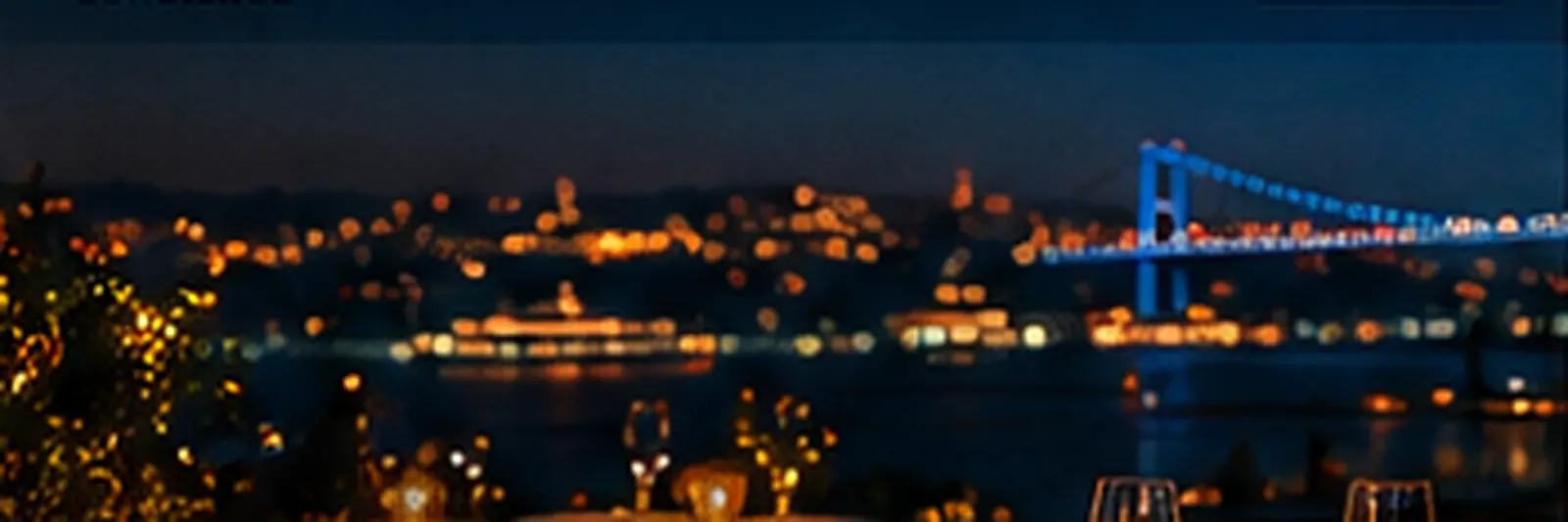 Istanbul at night: the Bosphorus bridge and a candle-lit table